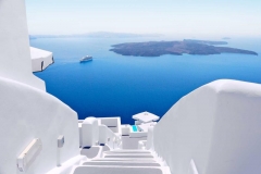 greece_santorini_white_concrete_staircases_leading_down_to_the_beautiful_bay_with_clear_blue_sky_and_sea_at_santorini